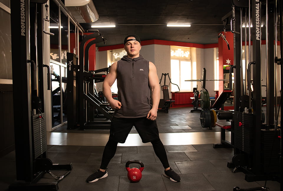 Тренер готовится к упражнению с гирей